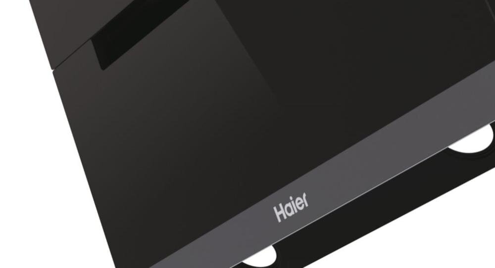 Czarny okap kuchenny z widocznym logo \'Haier\' na przednim panelu. Powierzchnia jest gładka i błyszcząca.