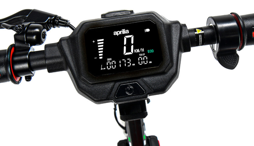 Wyświetlacz hulajnogi elektrycznej pokazuje prędkość 0 KM/H, tryb ECO oraz przebieg 173 km. Na ekranie widoczne jest logo \'aprilia\'.