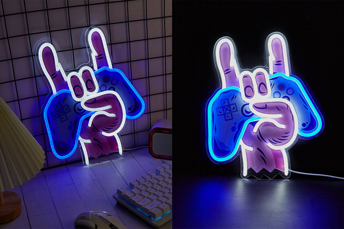 Neonowy znak w kształcie dłoni trzymającej gamepad, świecący na niebiesko i fioletowo. W tle widoczna jest kratka oraz biurko z klawiaturą i lampką.