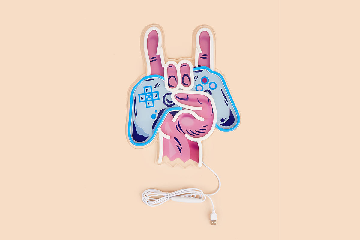 Neon LED w kształcie dłoni trzymającej gamepad, z podniesionymi palcami w geście rockowym. Do urządzenia podłączony jest biały kabel USB.