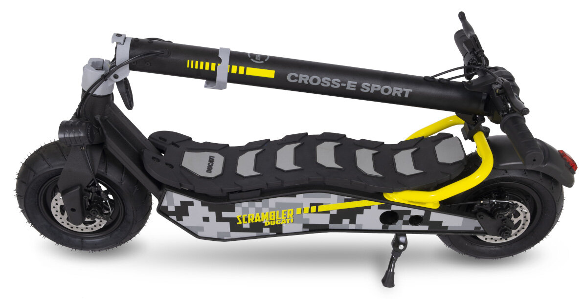Hulajnoga elektryczna w kolorze czarno-żółtym z napisem \'CROSS-E SPORT\' na kierownicy i \'SCRAMBLER DUCATI\' na boku. Posiada solidne opony i stojak.