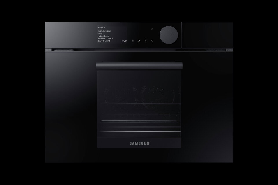 Czarny piekarnik elektryczny z mikrofalą marki Samsung z widocznym panelem sterowania i wyświetlaczem. Na drzwiach piekarnika znajduje się logo \'SAMSUNG\'.
