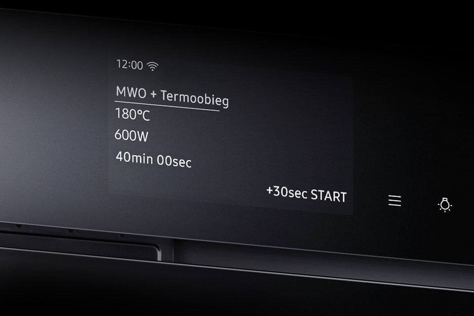 Wyświetlacz piekarnika pokazuje godzinę 12:00, tryb \'MWO + Termoobieg\', temperaturę 180°C, moc 600W oraz czas 40min 00sec. Widoczne są także przyciski \'+30sec START\' oraz ikony menu i oświetlenia.