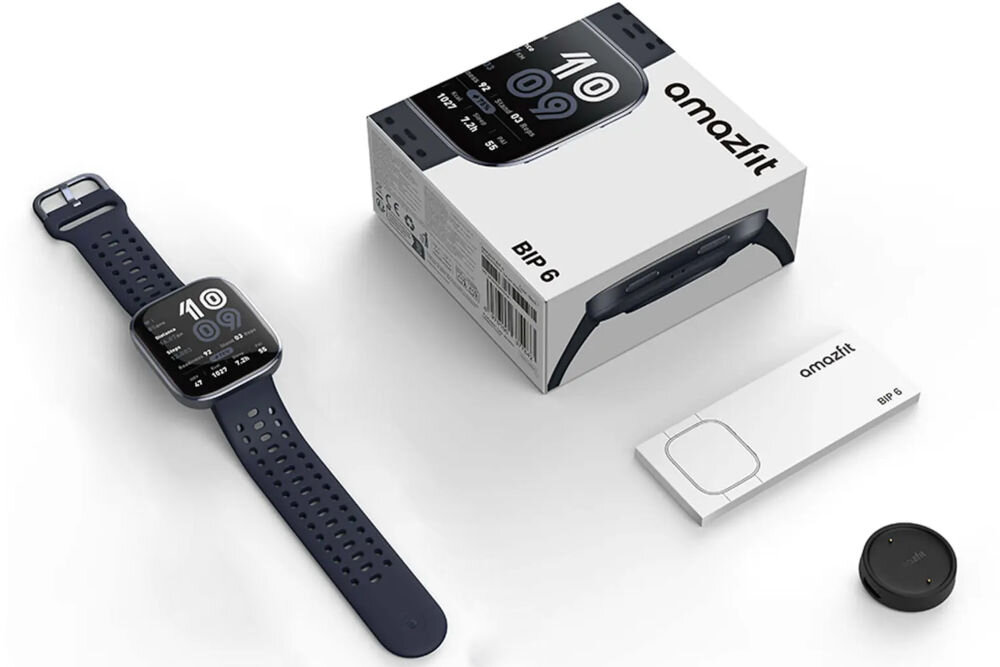 Na obrazie znajduje się smartwatch z czarnym paskiem, obok niego pudełko z napisem \'amazfit BIP 6\'. Widoczny jest również przewód do ładowania i okrągły element, prawdopodobnie stacja dokująca.