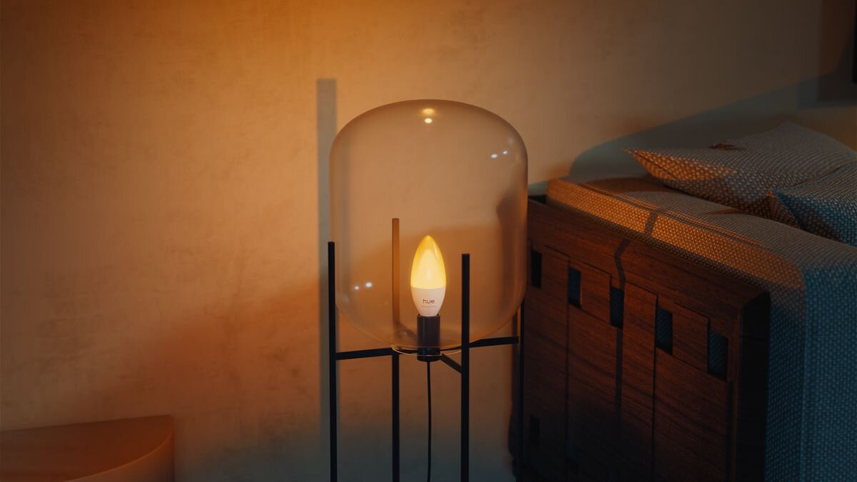 Inteligentna żarówka LED PHILIPS HUE Ambiance 929004295601 3.7W E14 Bluetooth, ZigBee, oszczędność, energii, trwałość, led, Szklana lampka z ciepłym światłem obok łóżka.