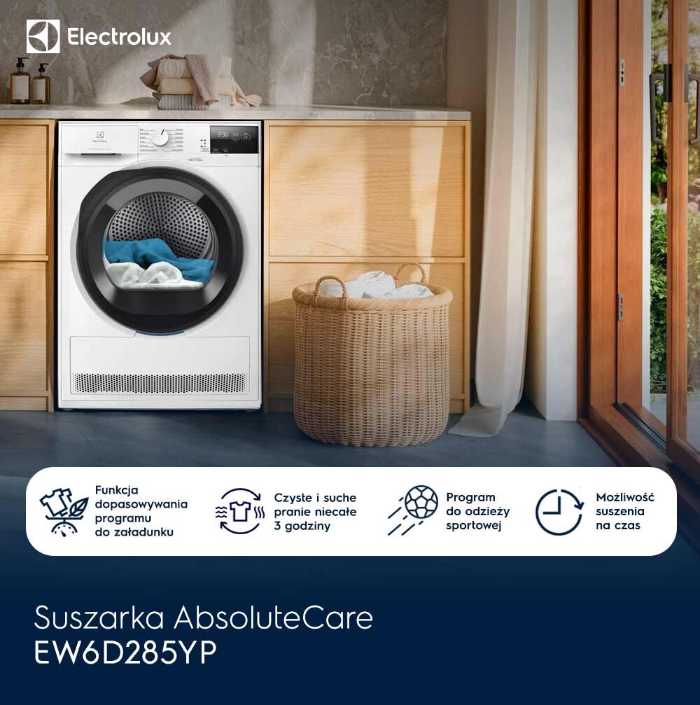 Na obrazie widoczna jest suszarka Electrolux umieszczona w jasnej kuchni, obok kosza z praniem. Na dole znajduje się tekst: \'Suszarka AbsoluteCare EW6D285YP\'.