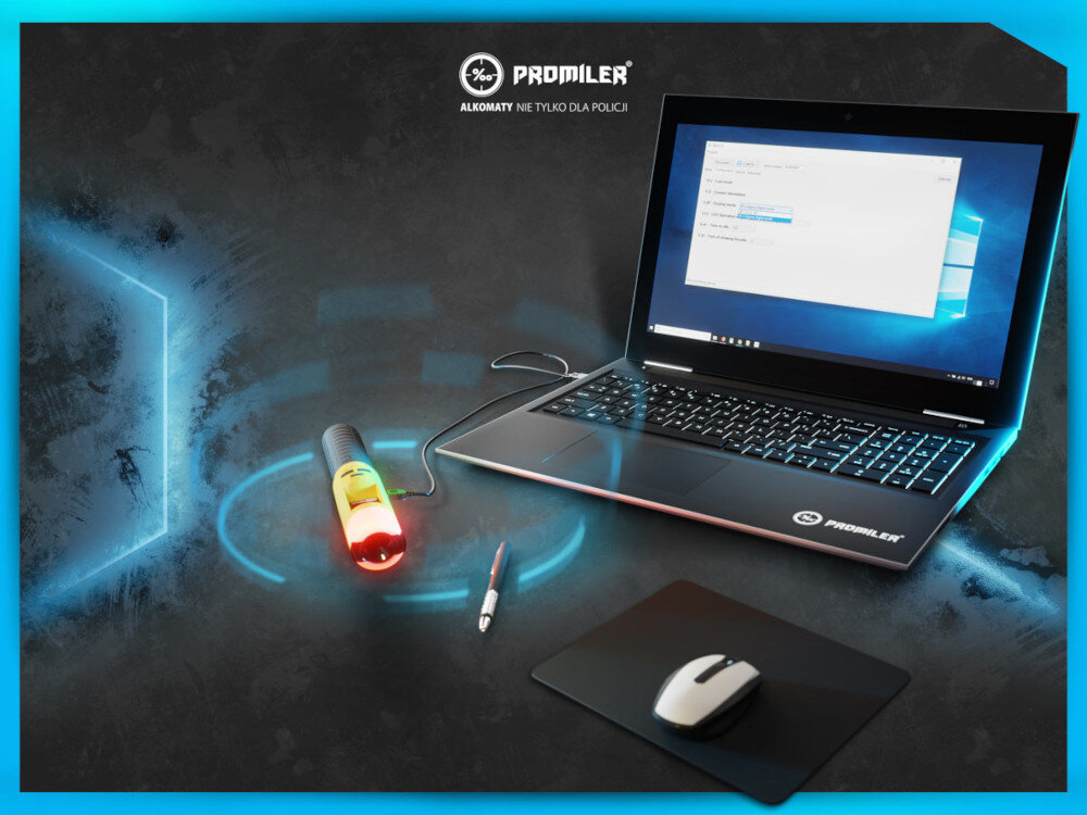 Na obrazie znajduje się otwarty laptop z widocznym ekranem, na którym wyświetlany jest system operacyjny. Obok laptopa leży alkomat z podświetleniem oraz mysz komputerowa na podkładce; w tle widoczne jest logo \'PROMILER\' i napis \'ALKOMATY NIE TYLKO DLA POLICJI\'.