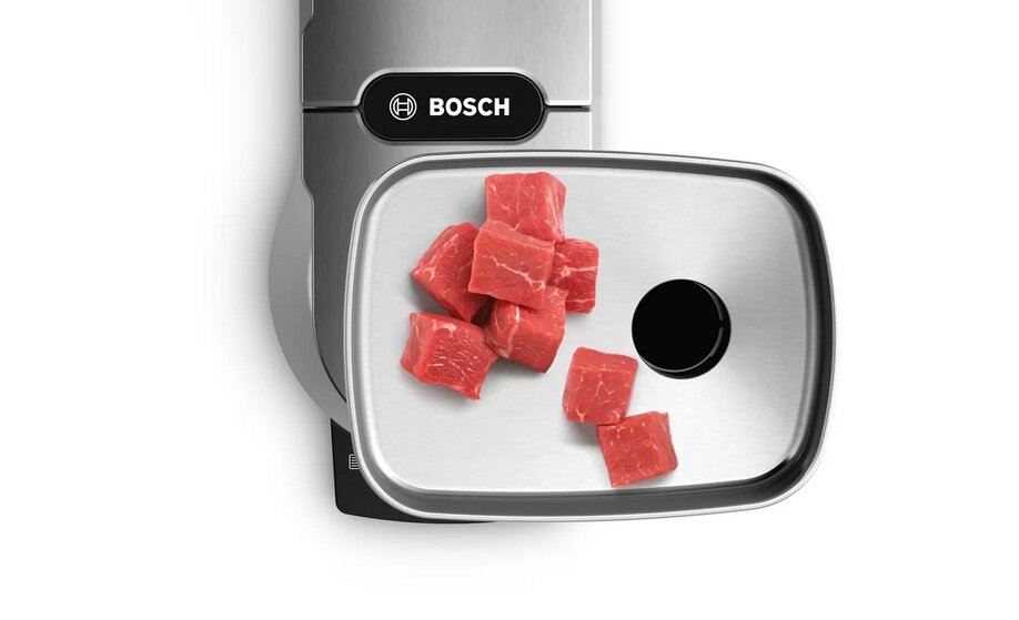 Na obrazie widoczna jest metalowa tacka z kawałkami czerwonego mięsa oraz logo \'BOSCH\'.