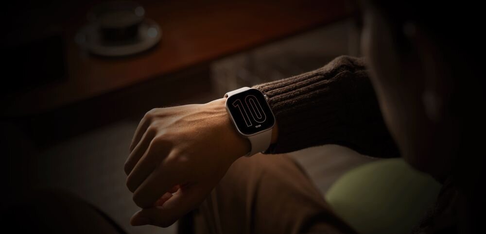 Osoba nosi smartwatch z dużym wyświetlaczem, na którym widoczna jest liczba \'10\'.
