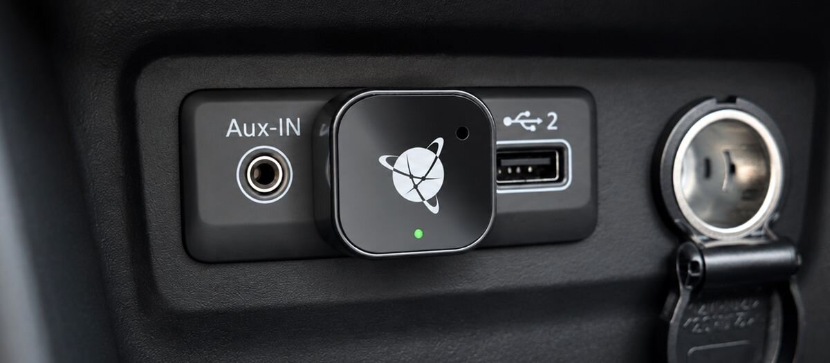 Adapter NAVITEL CPA5 Apple CarPlay Android Auto bezprzewodowy jednorazowa konfiguracja - podłączony w samochodzie, widoczny na tle ekranu systemu multimedialnego