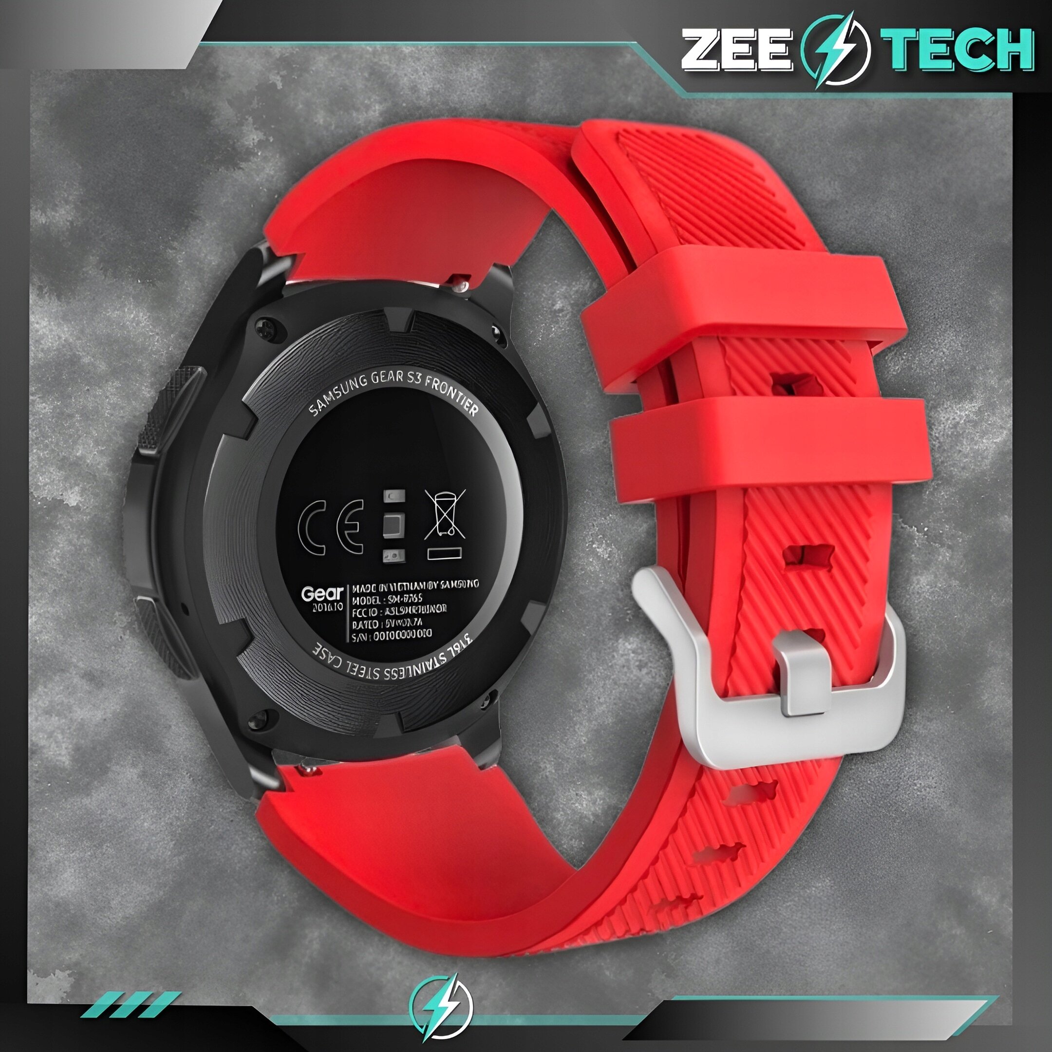 Czerwony silikonowy pasek do zegarka z metalową klamrą, widoczny na tle szarej powierzchni. Na zegarku widoczny jest napis \'SAMSUNG GEAR S3 FRONTIER\' oraz inne oznaczenia techniczne.