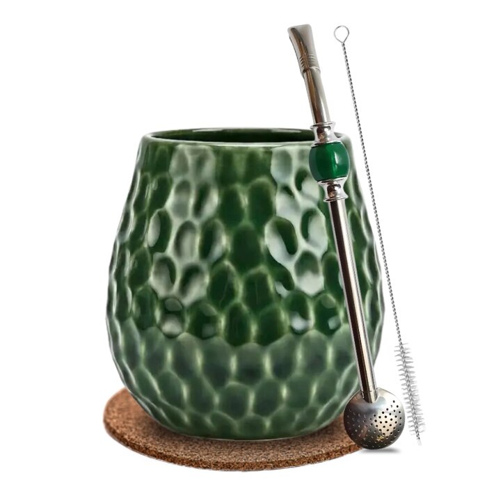 Zestaw do yerba mate składający się z zielonego, fakturowanego matero, metalowej bombilli z zielonym elementem oraz szczoteczki do czyszczenia. Całość umieszczona na okrągłej podkładce korkowej.
