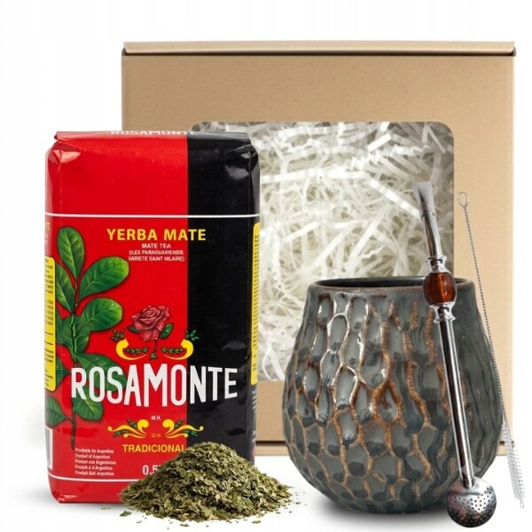 Na obrazie znajduje się opakowanie Yerba Mate Rosamonte Tradicional, ceramiczne matero o teksturowanej powierzchni oraz metalowa bombilla. W tle widoczny jest kartonowy zestaw prezentowy wypełniony białym wypełniaczem.