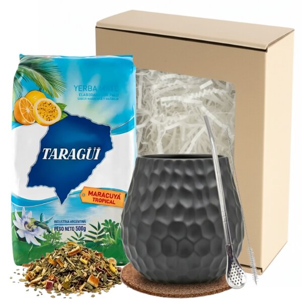 Na obrazie znajduje się opakowanie yerba mate marki Taragüi o smaku marakui, czarny kubek z metalową bombillą oraz kartonowe pudełko z wypełnieniem. Na opakowaniu widnieje napis: \'TARAGÜI MARACUYÁ TROPICAL\'.