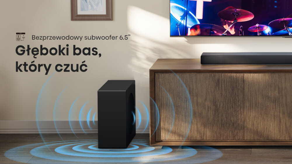 Na obrazie znajduje się czarny subwoofer obok drewnianej szafki z soundbarem na górze. Tekst na ścianie brzmi: \'Bezprzewodowy subwoofer 6.5\
