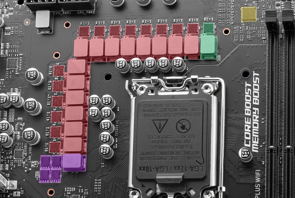 Zdjęcie przedstawia fragment płyty głównej z widocznym gniazdem procesora oraz elementami elektronicznymi w kolorach czerwonym, zielonym i fioletowym. Na płycie widoczny jest napis \'CORE BOOST MEMORY BOOST\'.