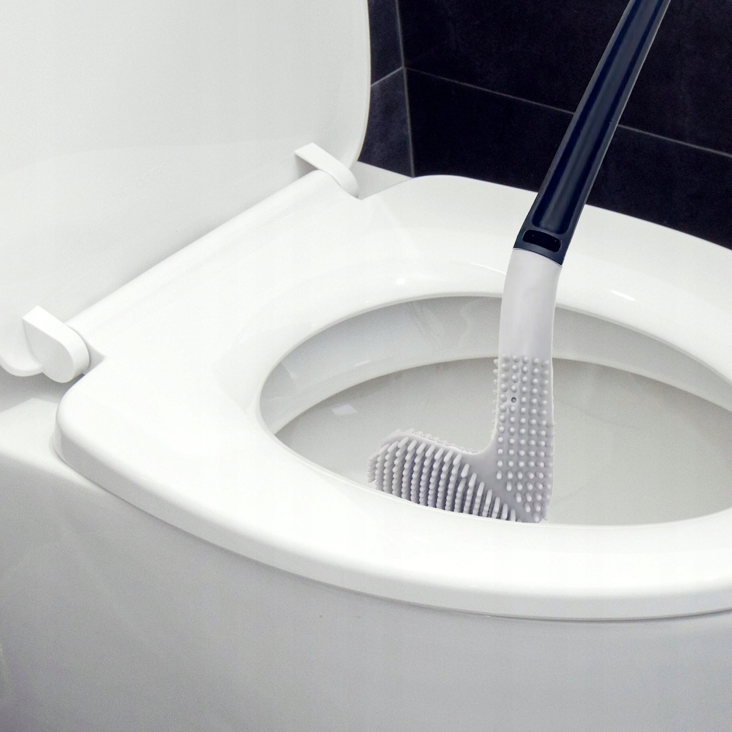 Szczotka do WC z silikonową główką włożona do muszli klozetowej. Szczotka ma ciemny uchwyt i jasną, elastyczną główkę z wypustkami.