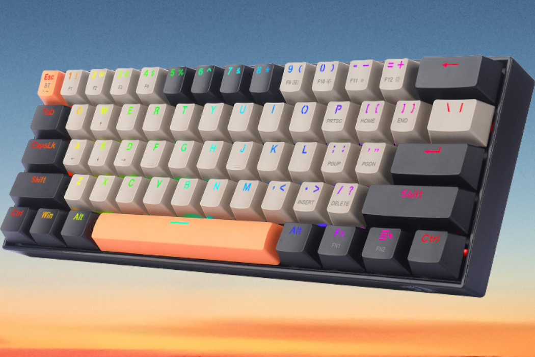 Klawiatura mechaniczna z kolorowymi klawiszami, w tym pomarańczowym klawiszem spacji i podświetleniem RGB. Widoczne są klawisze z oznaczeniami liter, cyfr i funkcji specjalnych.