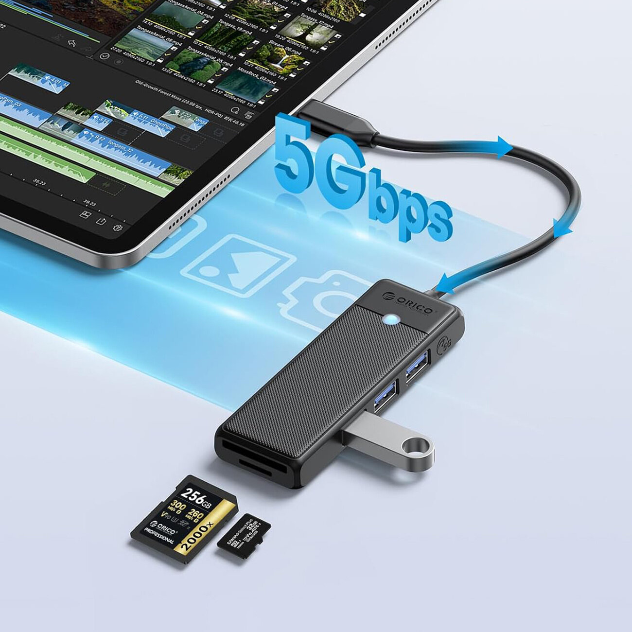 Na obrazie widoczny jest czarny hub USB marki Orico z trzema portami USB-A 3.0 i czytnikiem kart microSD/SD, podłączony do tabletu. Obok huba znajdują się karty pamięci microSD i SD oraz napis \'5Gbps\'.