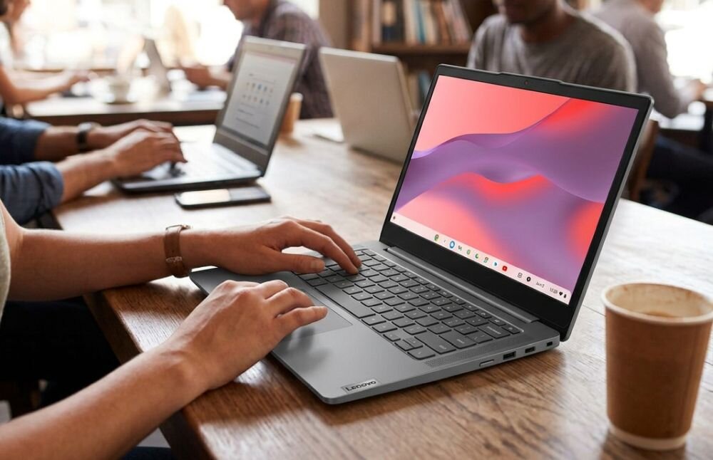 Osoba korzysta z laptopa Lenovo Chromebook podczas pracy i nauki przy wspólnym stole w przestrzeni co-workingowej