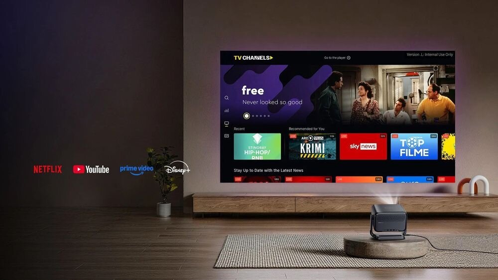 Menu systemu VIDAA OS w projektorze Dangbei N3 Max z dostępem do platform Netflix YouTube Prime Video i Disney+, projektor na stoliku wyświetlający obraz na ścianie