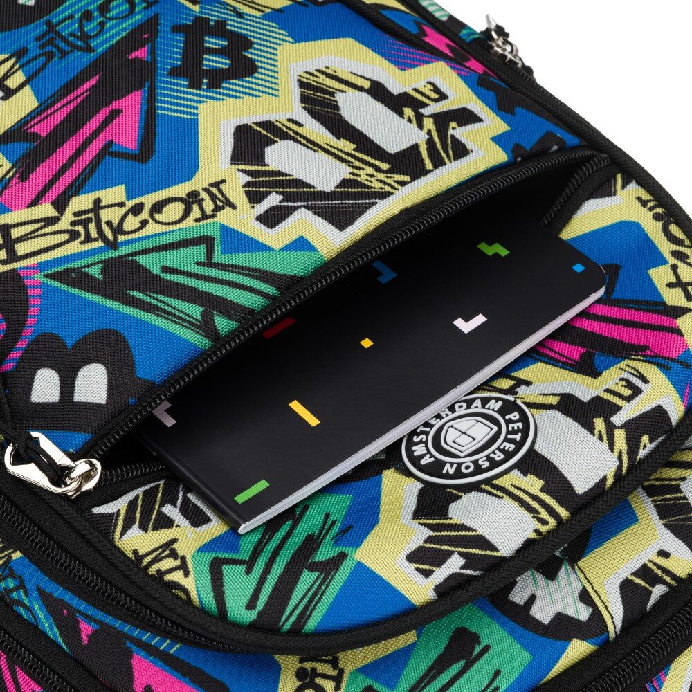 Kolorowy plecak z wzorami graffiti, z widocznym napisem \'Bitcoin\' i logo \'Amsterdam Peterson\'. W otwartej kieszeni znajduje się zeszyt z kolorowymi kwadratami na okładce.