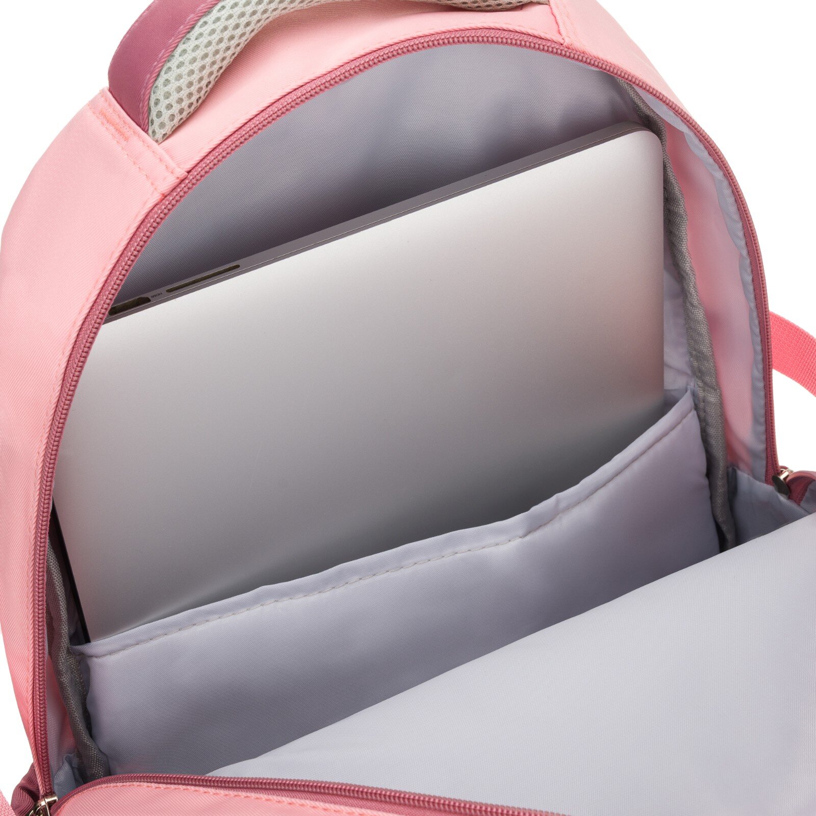 Wnętrze różowego plecaka z widoczną kieszenią, w której znajduje się laptop. Materiał wewnętrzny jest szary, a zamek błyskawiczny różowy.