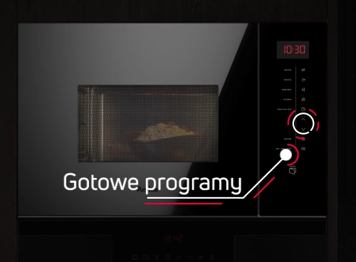 Czarna kuchenka mikrofalowa z wyświetlaczem pokazującym godzinę 10:30 i panel sterowania z przyciskami oraz pokrętłem. Na drzwiach widoczny napis \'Gotowe programy\'.