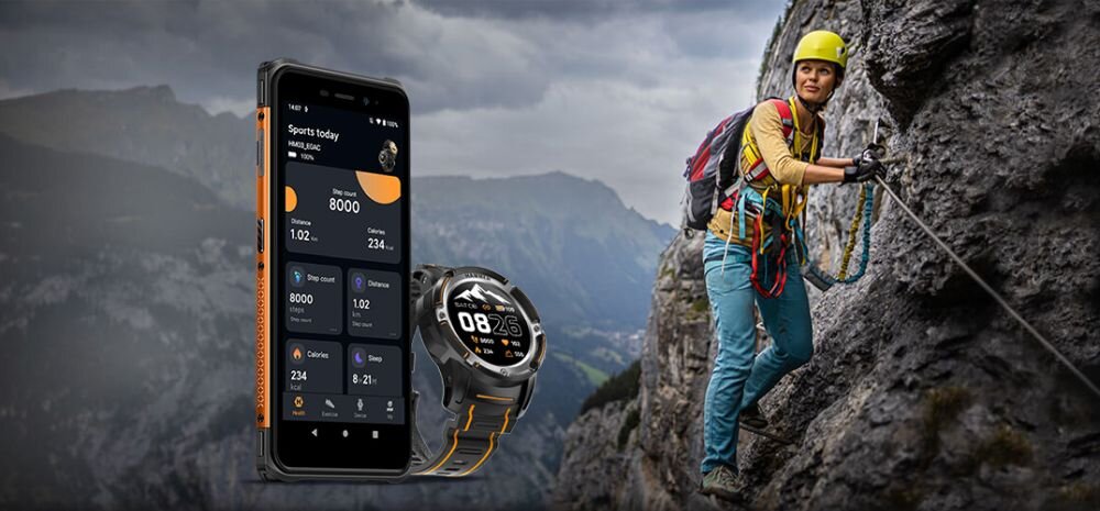 Obraz przedstawia osobę wspinającą się po skalnej ścianie z zabezpieczeniami, obok widoczny jest smartfon z aplikacją sportową oraz smartwatch z wyświetlaczem pokazującym godzinę 08:26.