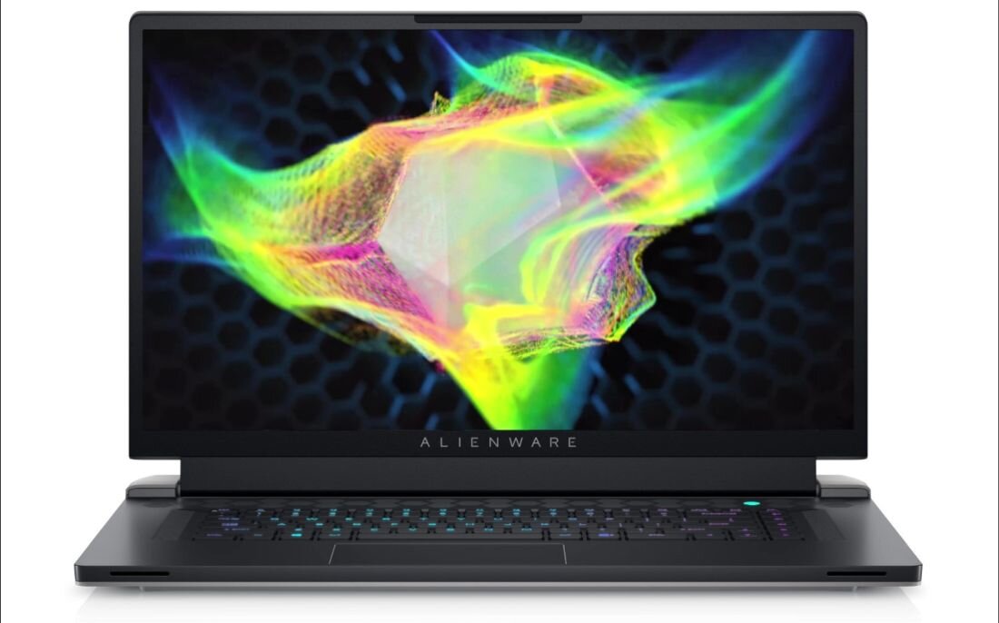 Laptop z wyświetlaczem pokazującym kolorową grafikę na tle ciemnego wzoru plastra miodu. Na dolnej ramce ekranu widoczny jest napis \'ALIENWARE\'.