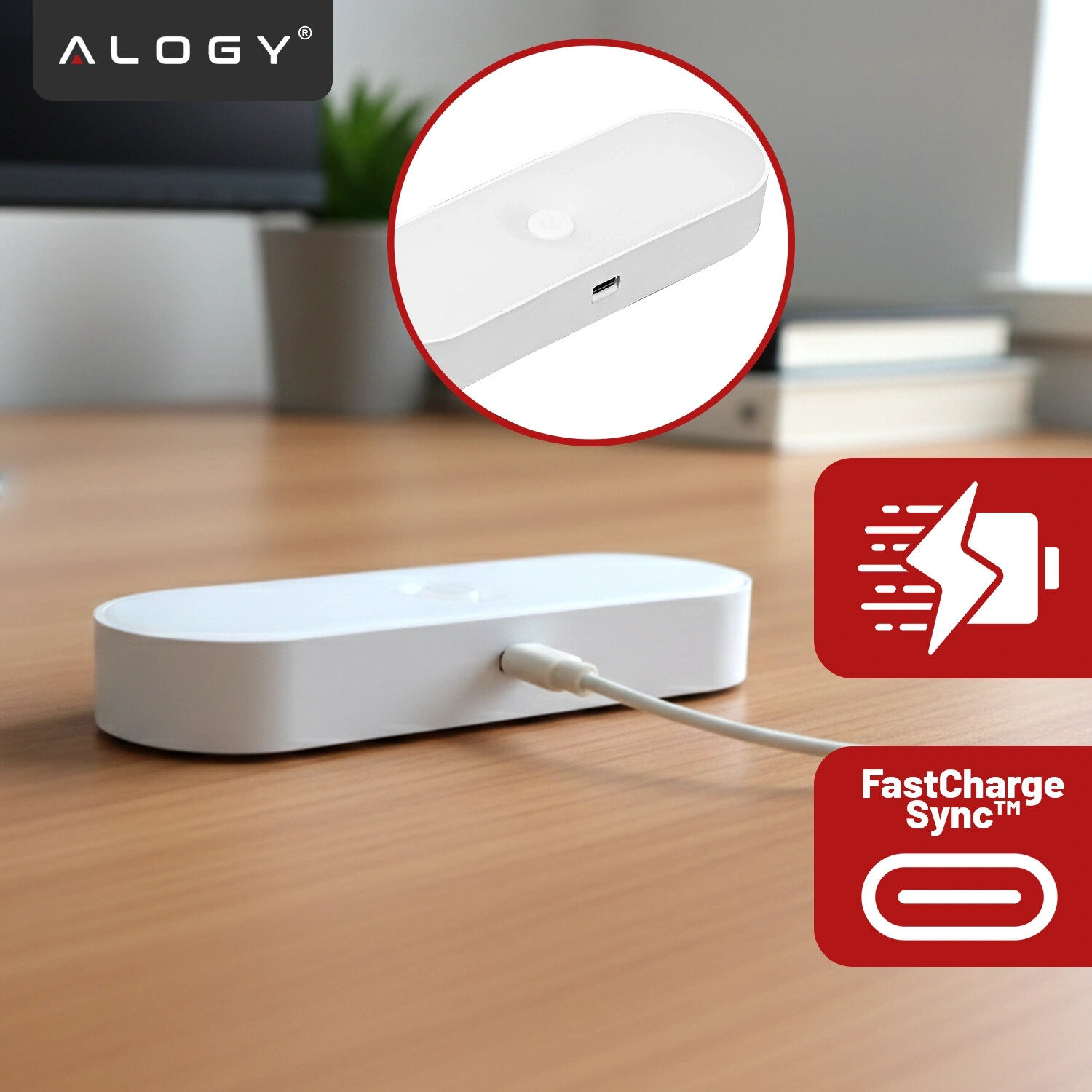 Na drewnianym blacie znajduje się biała, podłużna lampka z podłączonym kablem USB. W lewym górnym rogu widoczne jest logo \'ALOGY\', a po prawej stronie ikony z symbolami szybkiego ładowania i napisem \'FastCharge Sync™\'.