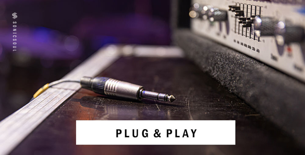 Na obrazie widoczny jest przewód z wtyczką jack leżący na powierzchni obok sprzętu audio. Na dole znajduje się napis \'PLUG & PLAY\', a po lewej stronie pionowy napis \'SONICSOUL\'.