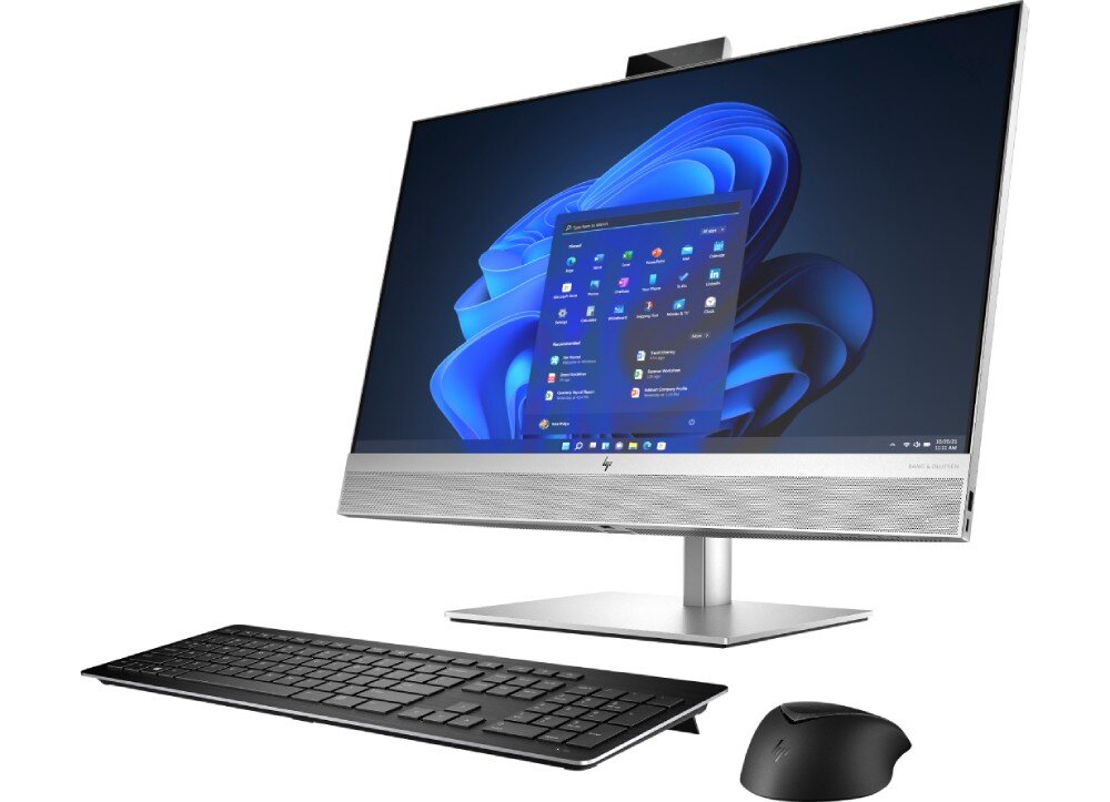 Na obrazie widoczny jest komputer stacjonarny typu all-in-one z dużym monitorem, klawiaturą i myszką. Na ekranie wyświetlany jest interfejs systemu Windows 11.