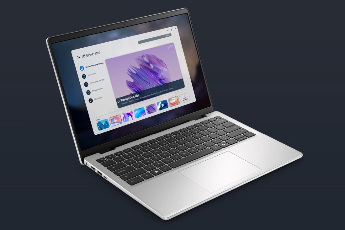 Na obrazie widać srebrny laptop z otwartym ekranem, na którym wyświetlana jest aplikacja z grafiką i menu po lewej stronie. Klawiatura jest czarna, a touchpad umieszczony centralnie pod klawiaturą.