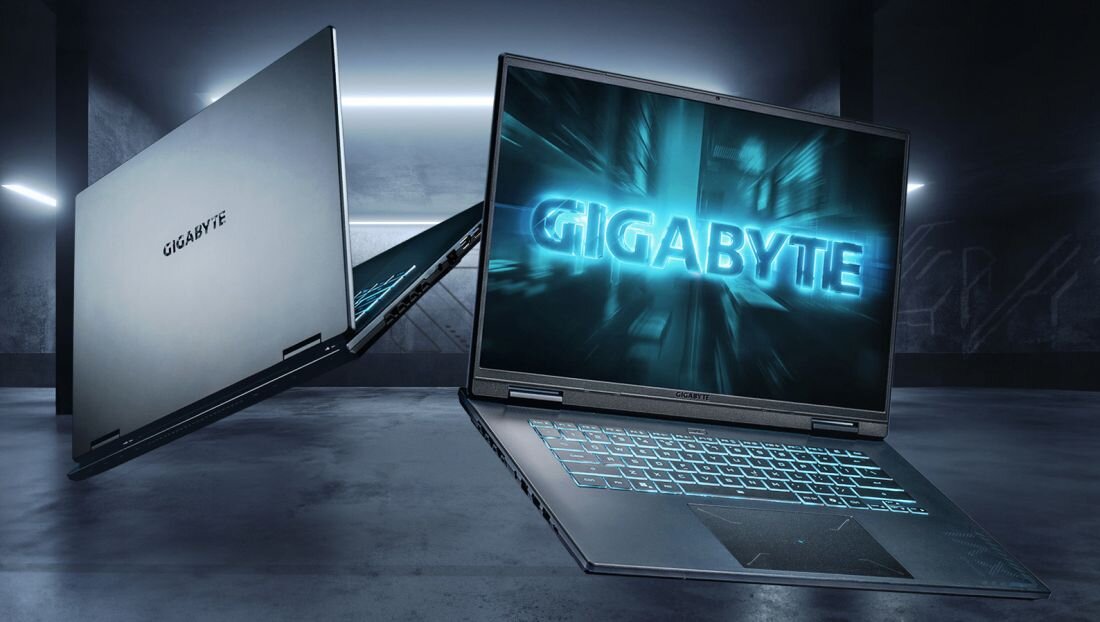 Dwa laptopy z logo GIGABYTE na ekranach, umieszczone w futurystycznym, ciemnym pomieszczeniu z neonowym oświetleniem.