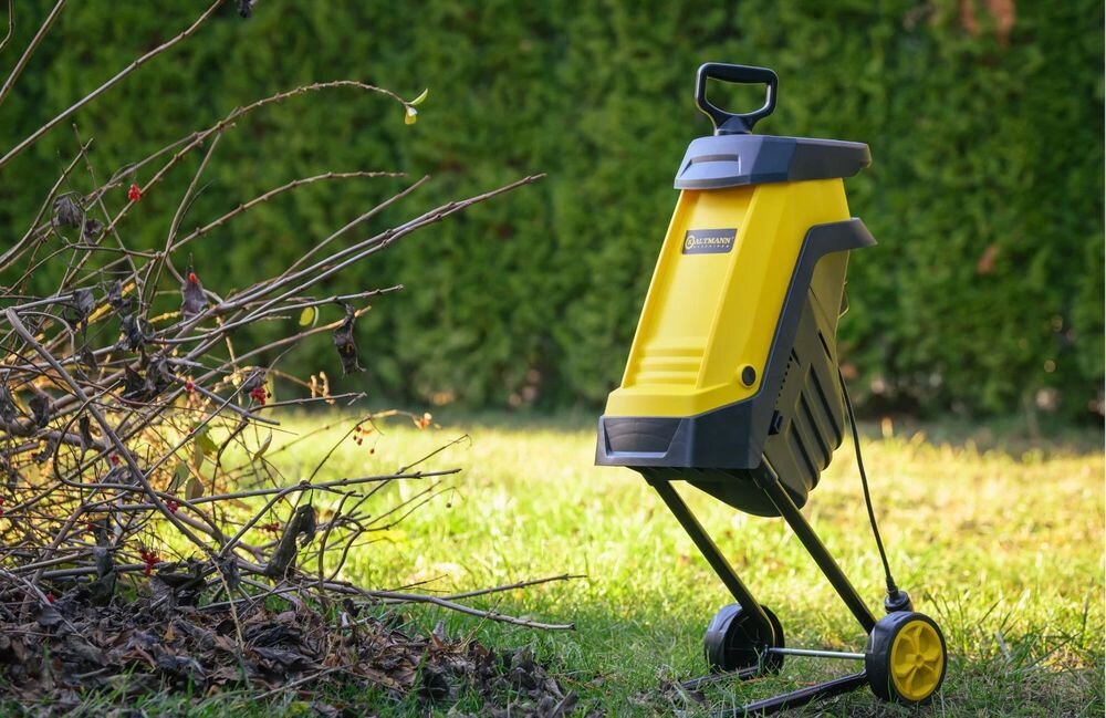 Rozdrabniacz do gałęzi KALTMANN K-RDG-2400 elektryczny 2400W średnica cięcia 45mm, przechowywanie, garaż, gabaryty, obudowa, Żółto-czarny rozdrabniacz ogrodowy stojący na trawniku.