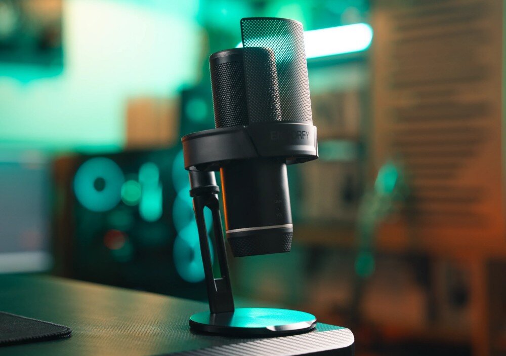 Mikrofon ENDORFY Solum 2 Pro Mikrofon na okrągłej podstawie ze zintegrowaną osłoną pop-filtr stoi na brzegu ciemnego blatu