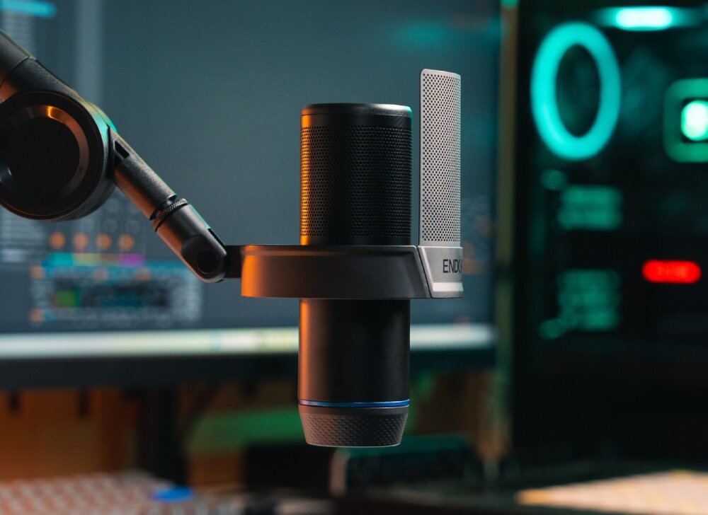 Mikrofon ENDORFY Solum 2 Boom Arm Mikrofon zamontowany na przegubowym ramieniu na tle włączonego monitora