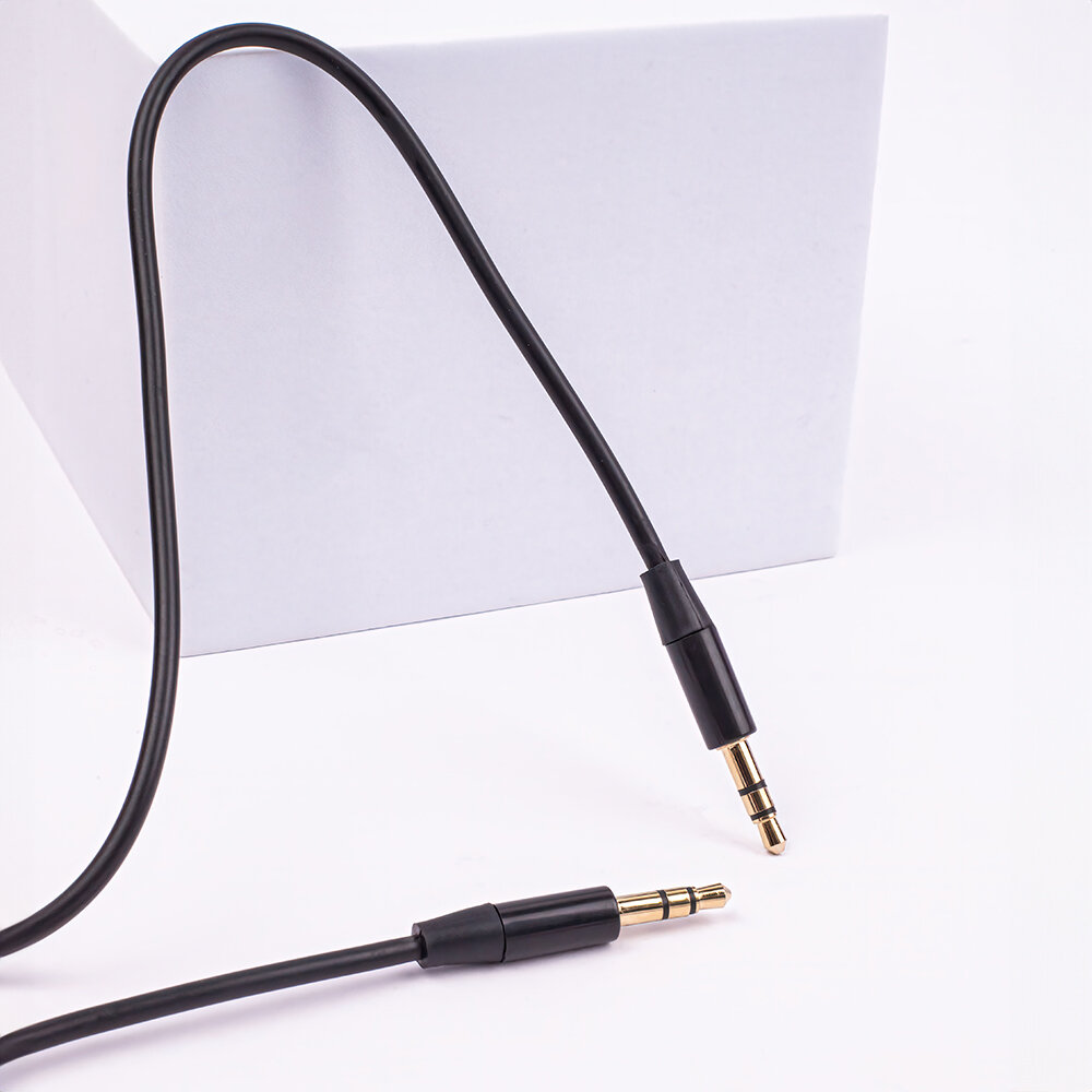 Czarny kabel audio z dwoma wtykami Jack 3,5 mm na białym tle. Kabel jest częściowo zwinięty, a wtyki są złote.