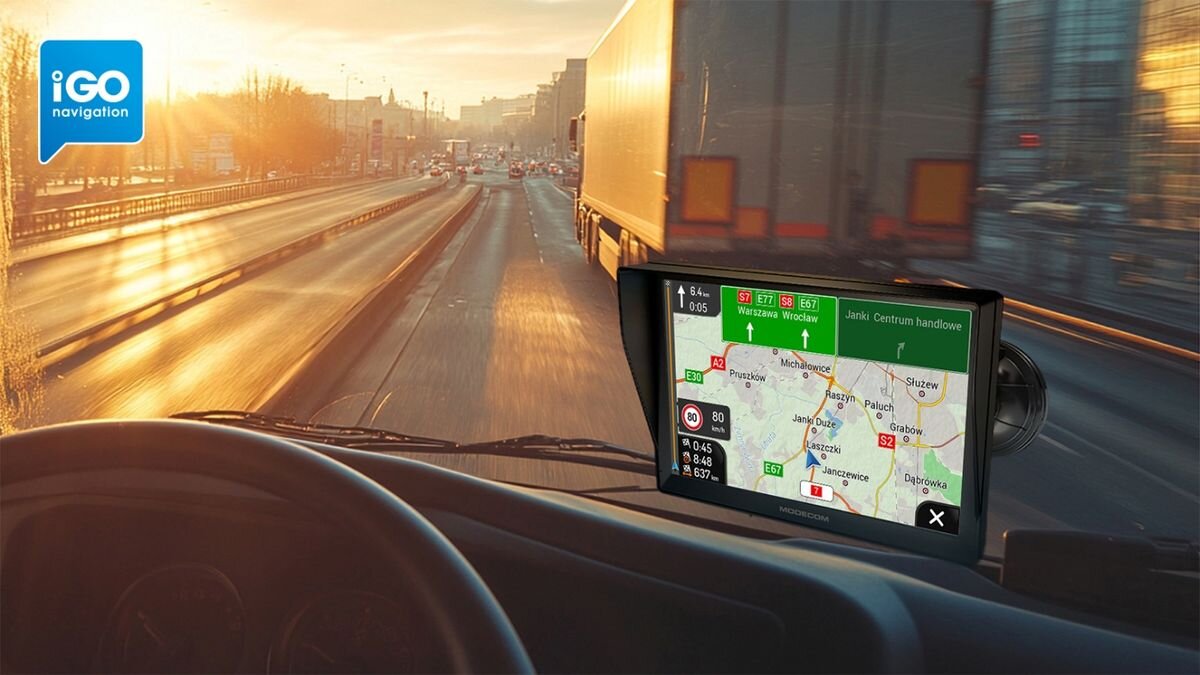 Widok z wnętrza pojazdu na drogę, z nawigacją GPS pokazującą mapę i trasę. W lewym górnym rogu widoczne jest logo \'iGO navigation\'.