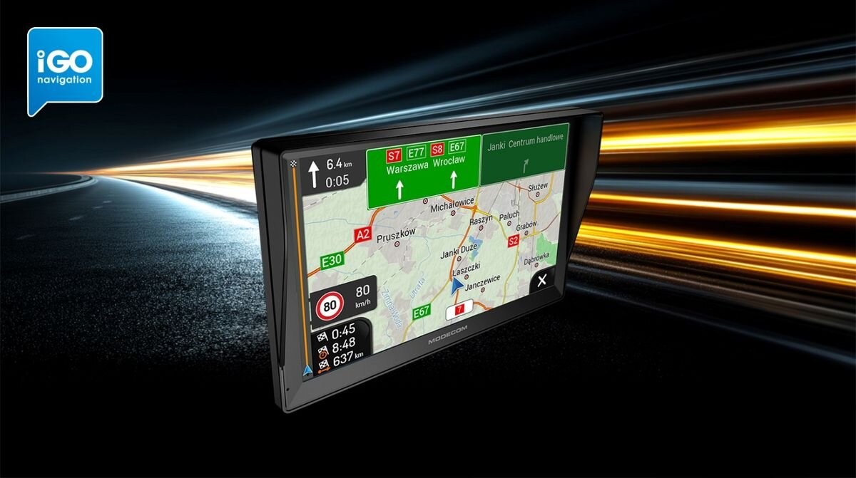 Obraz przedstawia urządzenie nawigacyjne z wyświetlaczem pokazującym mapę z trasą i informacjami drogowymi. W lewym górnym rogu widoczne jest logo \'iGO navigation\'.