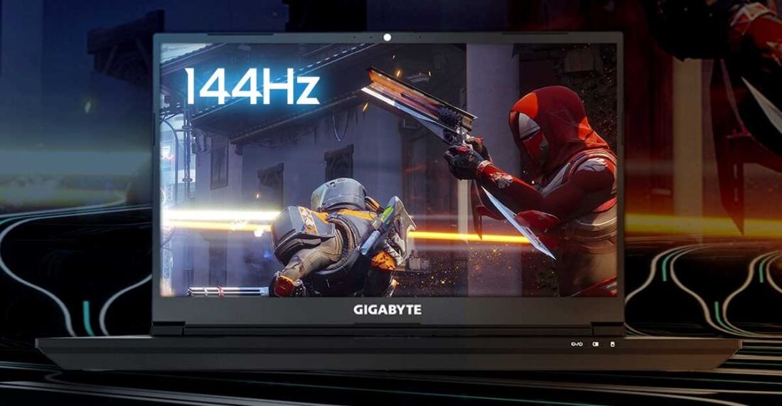 Laptop z widocznym logo GIGABYTE na dolnej ramce ekranu, wyświetlający dynamiczną scenę z gry oraz tekst \'144Hz\'.