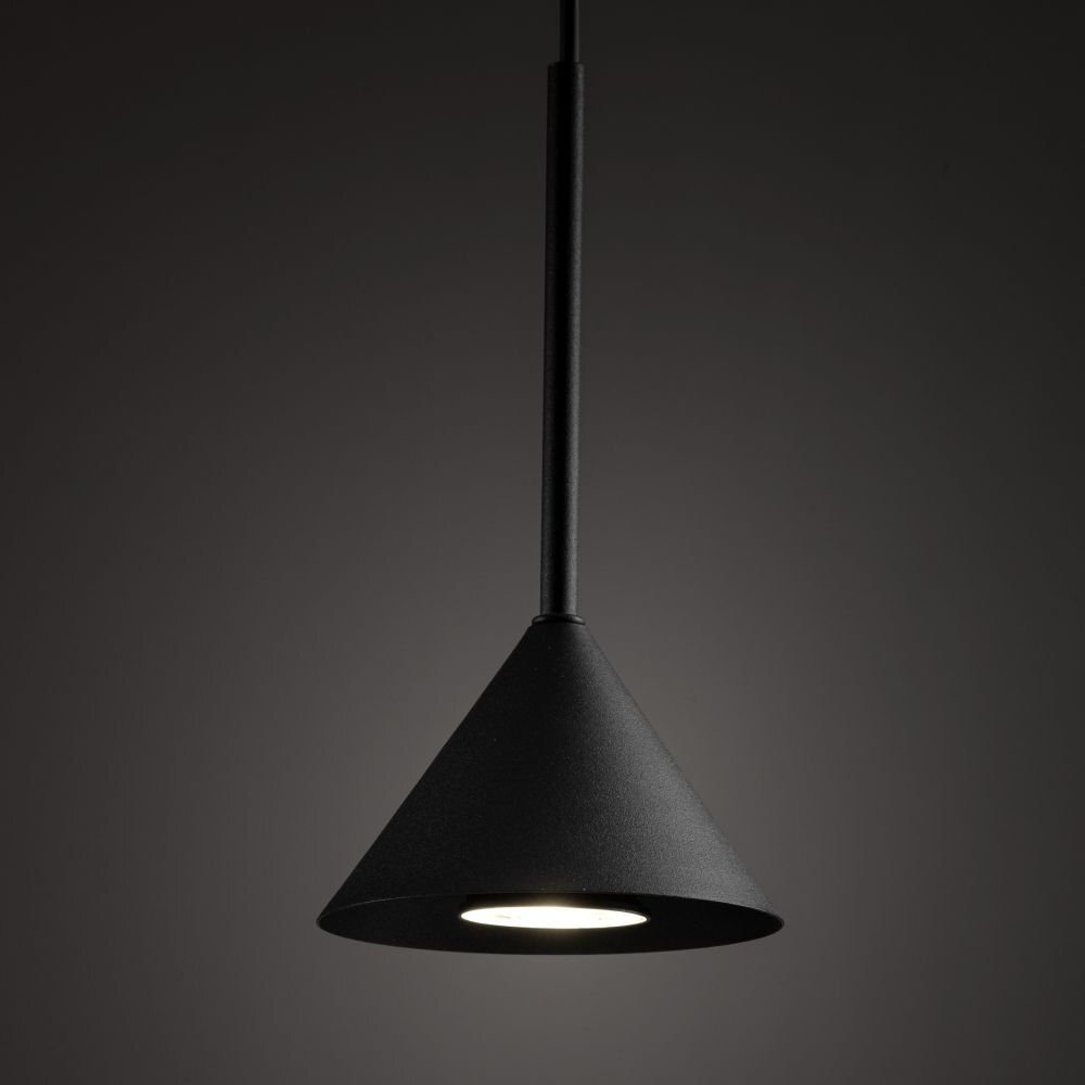 Czarna, stożkowa lampa wisząca z widocznym źródłem światła na ciemnym tle. Lampa ma prosty, nowoczesny design.