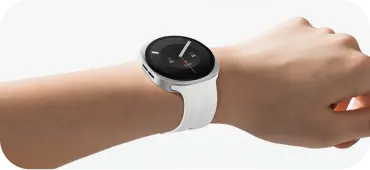 Dłoń z białym smartwatchem o okrągłej tarczy i wskaźnikach aktywności. Na zdjęciu widoczny jest smartwatch z okrągłą tarczą i białym paskiem, założony na nadgarstku. Tarcza zegarka jest czarna z prostymi wskazówkami i oznaczeniami godzinowymi.