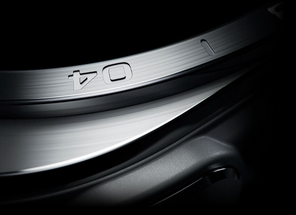 Galaxy Wach Ultra 2 – Wytrzymały i stylowy Zbliżenie na metalową ramkę urządzenia z wygrawerowanymi symbolami: strzałką i kwadratem. Powierzchnia jest gładka i błyszcząca.
