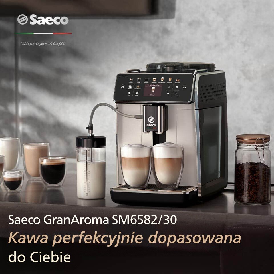 Na obrazie znajduje się srebrny ekspres do kawy z logo Saeco, obok którego stoją szklanki z różnymi rodzajami kawy. Widoczny jest tekst: \'Saeco GranAroma SM6582/30 Kawa perfekcyjnie dopasowana do Ciebie\'.