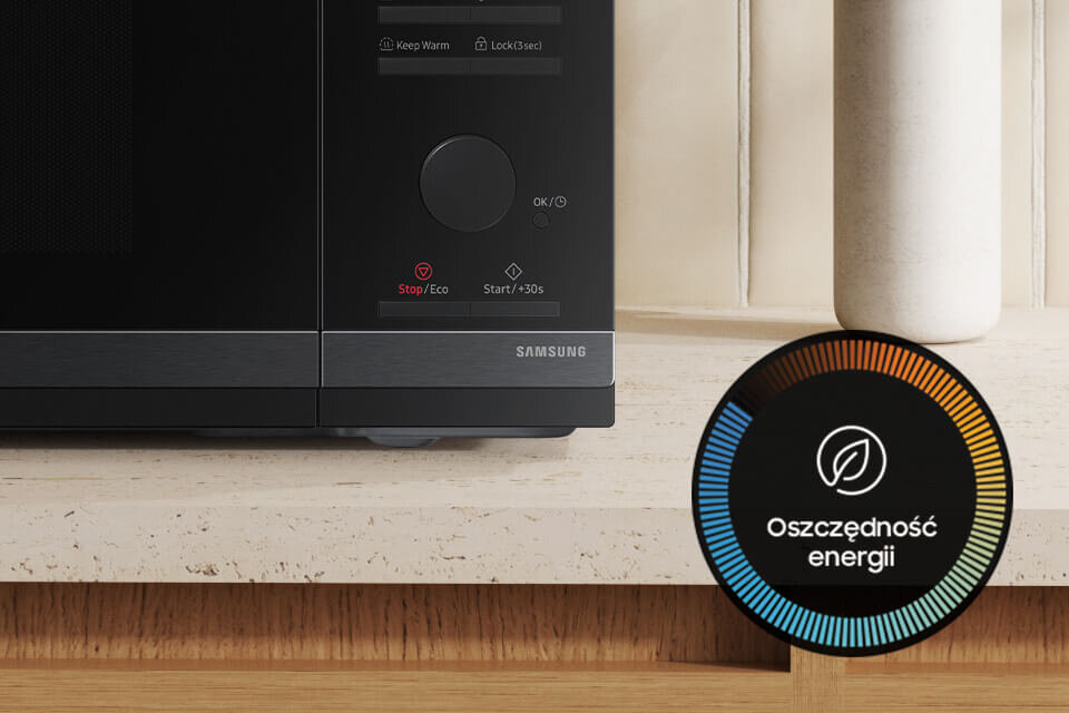 Czarna kuchenka mikrofalowa z widocznymi przyciskami \'Stop/Eco\' i \'Start/+30s\', oraz logo \'SAMSUNG\'. Obok znajduje się okrągły symbol z napisem \'Oszczędność energii\'.