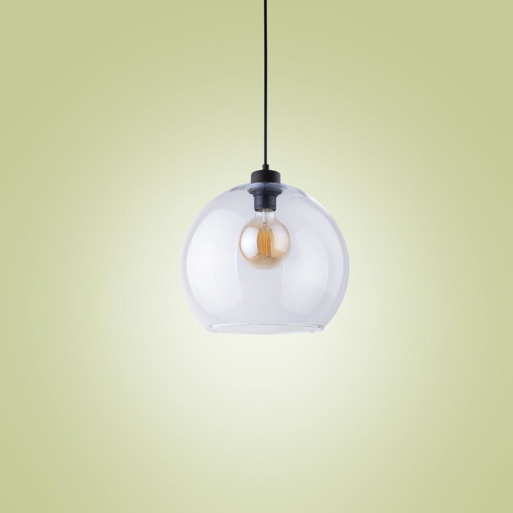 Szklana lampa wisząca z widoczną żarówką wewnątrz, zawieszona na czarnym kablu. Tło jest jednolite, w jasnym odcieniu zieleni.