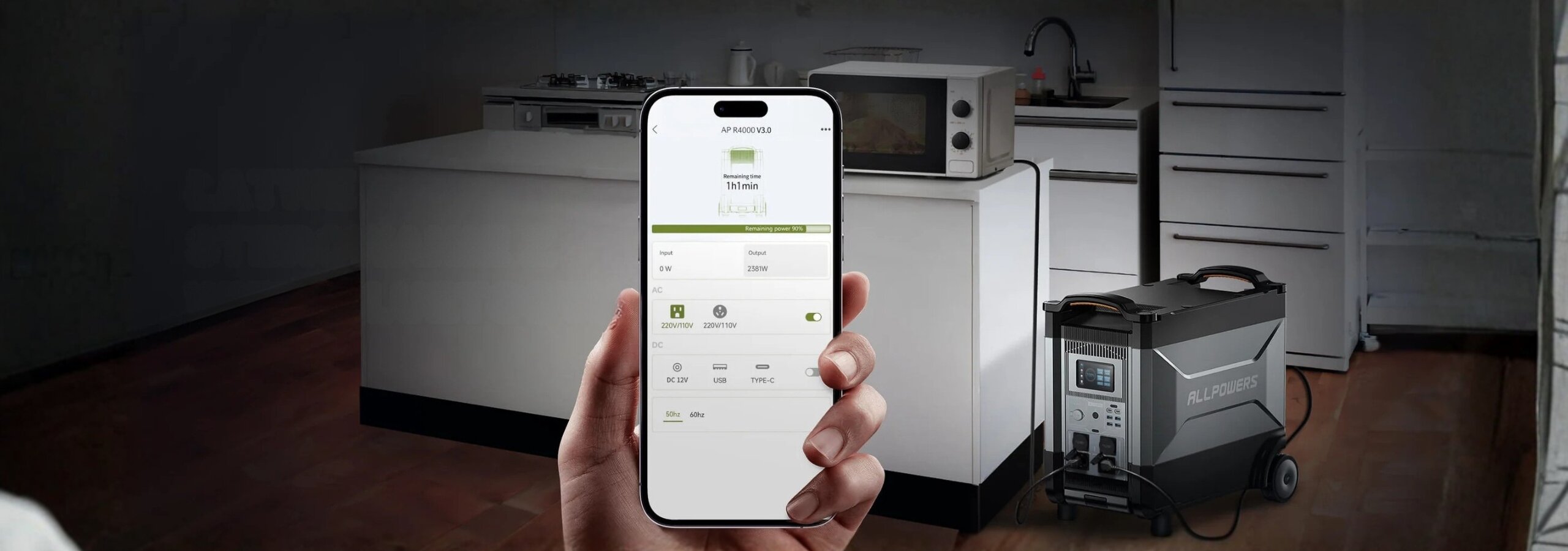 Osoba trzyma smartfon z aplikacją pokazującą status urządzenia. W tle widać kuchnię z mikrofalówką i urządzeniem Allpowers R4000 na podłodze.