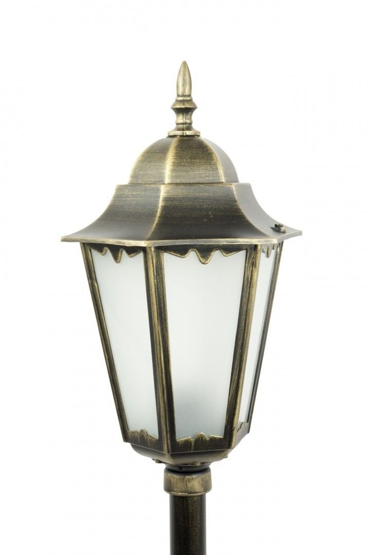 Lampa ogrodowa stojąca w stylu retro, wykonana z metalu w kolorze patyny mosiądzu, z ozdobnym szczytem i matowymi szybami. Konstrukcja ma klasyczny, elegancki wygląd.